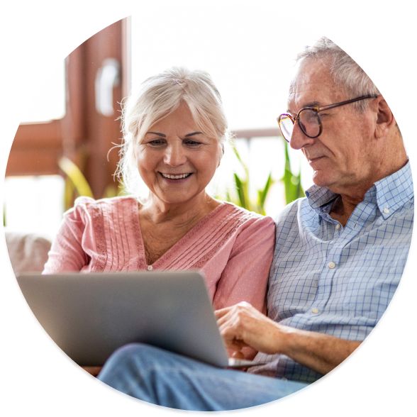 Elderly couple reviewing Medicare plans on laptop